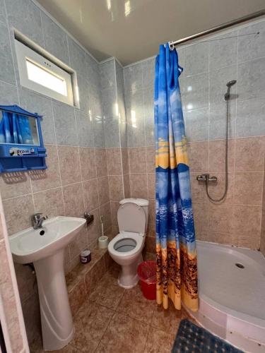 a bathroom with a toilet and a sink and a shower at Эдем ИссыкКуль in Bosteri