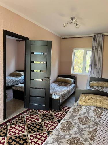a bedroom with two beds and a dresser in it at Эдем ИссыкКуль in Bosteri