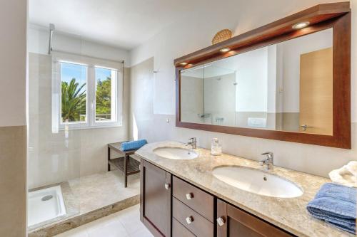 a bathroom with two sinks and a large mirror at Mon Obert Cala Serena in Felanitx