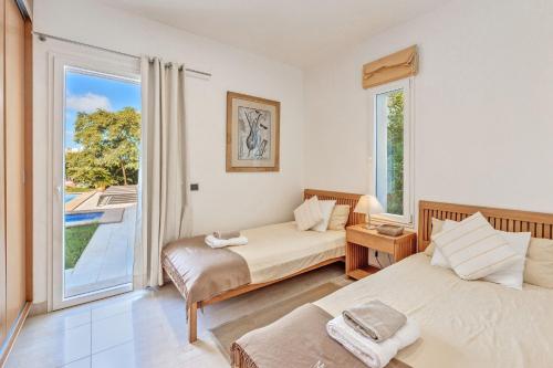 a bedroom with two beds and a large window at Mon Obert Cala Serena in Felanitx