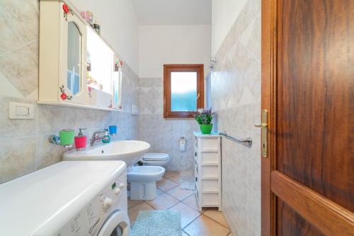 a white bathroom with a sink and a toilet at Trilocale Luana in Nuditta
