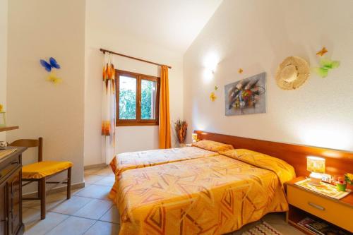 a bedroom with a bed with a yellow comforter at Trilocale Luana in Nuditta