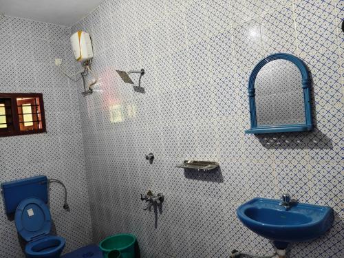 a bathroom with a blue sink and a toilet at Quality Inn Resort in Varkala