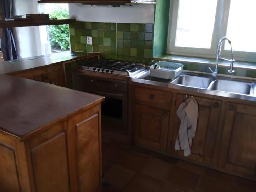 a kitchen with a sink and a stove at Gîte De Ty Louti in Plouyé