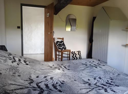 a bedroom with a bed and a wooden chair at Gîte De Ty Louti in Plouyé