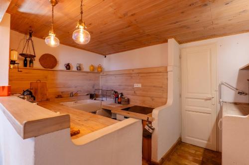 a kitchen with wooden walls and a wooden ceiling at Cocooning in Puimoisson
