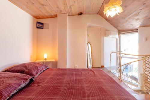 a bedroom with a large bed with a red blanket at Cocooning in Puimoisson