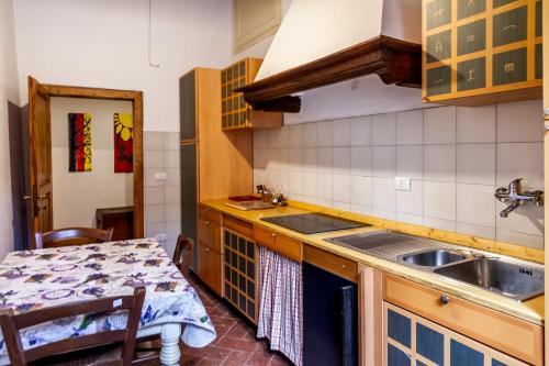 a kitchen with a sink and a table at Residenza Palazzo Ghio in Scansano