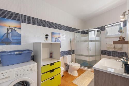 a bathroom with a toilet sink and a washing machine at Casa Amarela in Ponte de Vagos