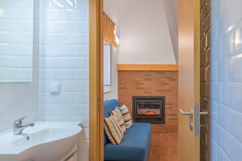 a bathroom with a blue chair and a fireplace at Casa Da Ti Vanda in São Luis