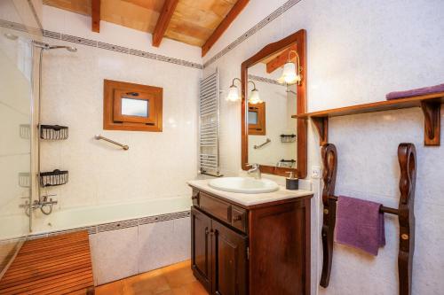 a bathroom with a sink and a tub and a mirror at Tramuntana in Valldemossa