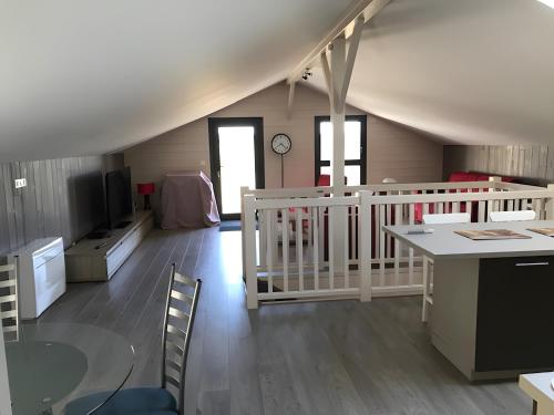 a room with a kitchen and a living room with a table at Loft Grand Confort Avec Piscine in Montalzat
