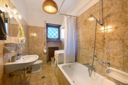 a bathroom with a tub and a sink and a toilet at Katharina in Lana