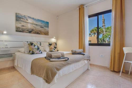a bedroom with a bed with a large window at Oasis Duna _ Casa Martineli Pool in Corralejo