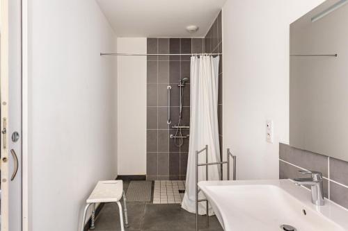 a white bathroom with a shower and a sink at Gîte De L'orchidée in Saint-Épain