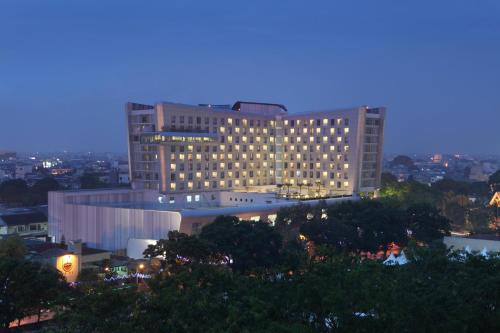 a large building with lights on in a city at night at Santika Premiere Dyandra Hotel & Convention - Medan in Medan