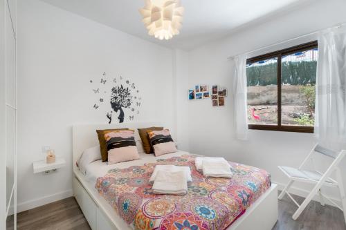 a bedroom with a bed in a white room at Apto Jardin del Sol Beach-Pool in Puerto de Santiago