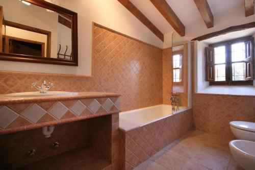 a bathroom with a tub and a sink and a toilet at Butxaco in Pollença