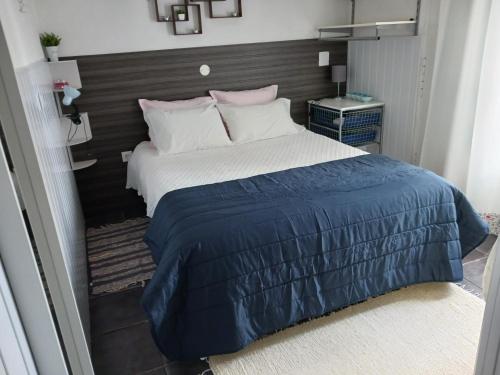 a bedroom with a large bed with a blue blanket at Casa de Jardim in Ponte de Sor