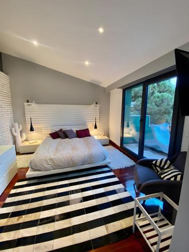 a bedroom with a bed and a large window at Design villa with sea views in San Pol de Mar