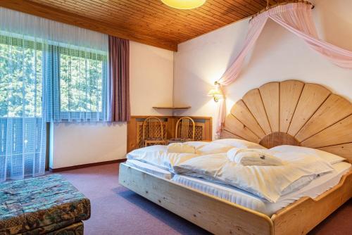 a bedroom with a large bed with a wooden headboard at Sabina Dolomites Piz in Alpe di Siusi