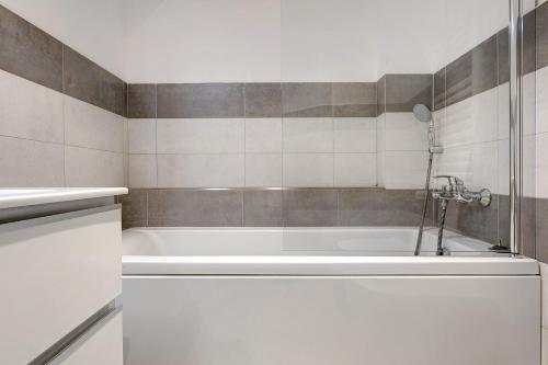 a white bath tub in a bathroom with tiles at Solaria in Rapallo
