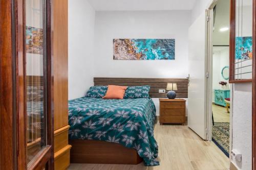 a bedroom with a bed and a painting on the wall at Apto Casco viejo Castro Urdiales in Castro-Urdiales