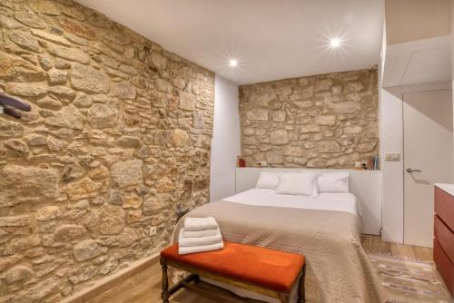 a bedroom with a stone wall and a bed at Old Side Girona one in Girona