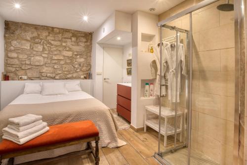 a bedroom with a bed and a glass shower at Old Side Girona one in Girona