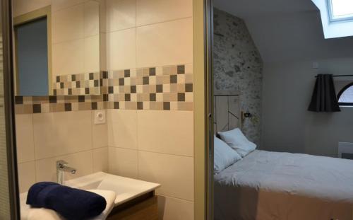 a small bathroom with a bed and a sink at Chambres D'hôtes Le Fer À Cheval in Montreuil-sur-Maine