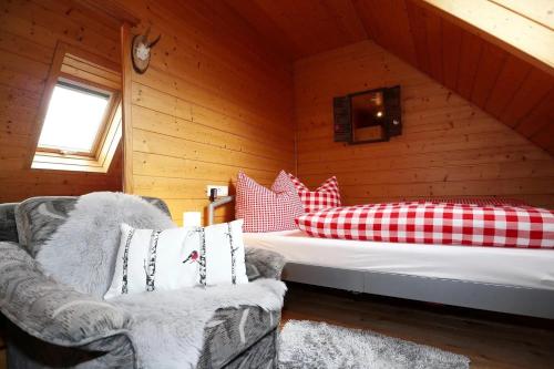 a bedroom with a bed and two chairs in a cabin at Wohnung im Gästehaus Waldhüsle in Friedenweiler