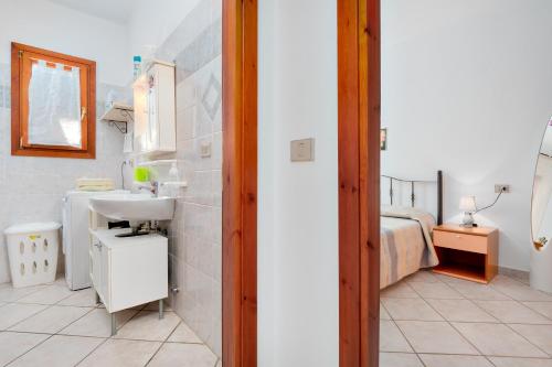 a bathroom with a sink and a bed in a room at Villa Bianca in San Teodoro