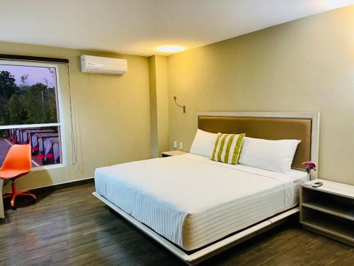 a bedroom with a large bed and a window at Hotel Royal Garden Tuxpan in Cobos