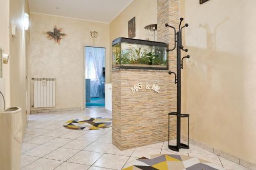 a room with a fish tank on a brick wall at Casa laureta in Piombino