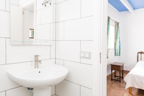 a white bathroom with a sink and a bed at Cala Serena Beach 6 in Felanitx