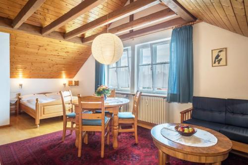 a living room with a dining room table and a bedroom at Haus Kremeier in Kressbronn am Bodensee