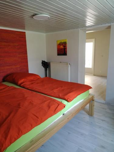 a bedroom with a large bed with red sheets at Haus im Grünen in Calau