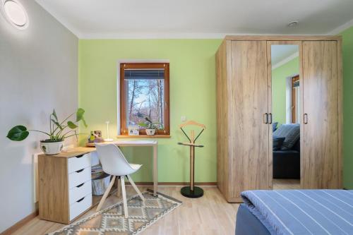 ein Schlafzimmer mit grünen Wänden, einem Schreibtisch und einem Bett in der Unterkunft Spreequartier in Malschwitz