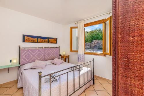 a bedroom with a bed and a window at 1 Appartamento Lu Impostu in San Teodoro