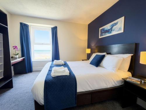 a hotel room with a bed and a window at The Esplanade Hotel by Compass Hospitality in Paignton