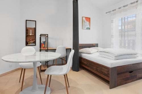 a bedroom with a bed and a table and chairs at Studio 2 proche centre avec parking in Fréjus