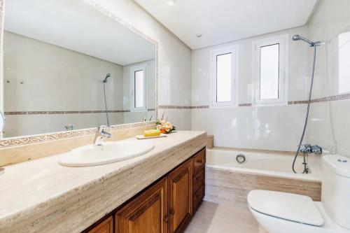 a bathroom with a sink and a toilet and a mirror at Alcanada Paradise in Alcudia