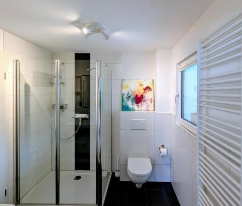 a bathroom with a toilet and a glass shower at Ferienwohnung Lichtenstein in Lichtenstein