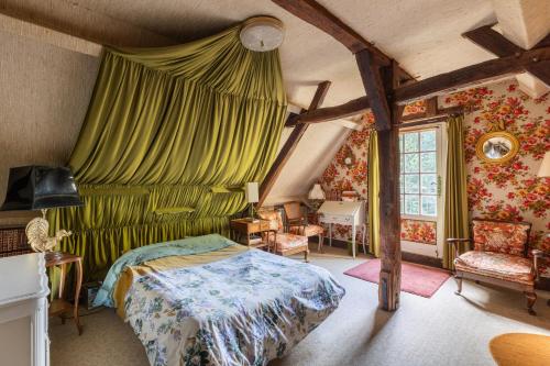 a bedroom with a bed and a green curtain at La Closerie du Cassereau in Vernou-sur-Brenne