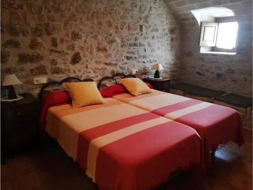 a bedroom with two beds with red and white sheets at Mas Pareta - La Parra 1 in Fonolleras
