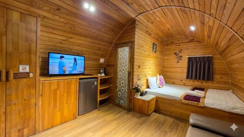 a small room with a bed and a tv in a cabin at Mi Lan Villa Hotel in Vung Tau