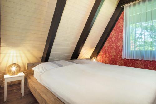 a bedroom with a large bed with a window at Ferienhaus Exquisit in Immenstaad am Bodensee