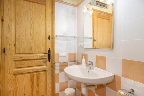 a bathroom with a sink and a wooden door at Casa Ramona in Conques