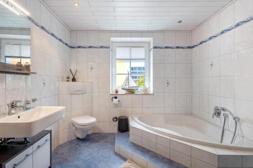 a bathroom with a tub and a toilet and a sink at Teichmühle - Vogtland Chalet in Bad Brambach