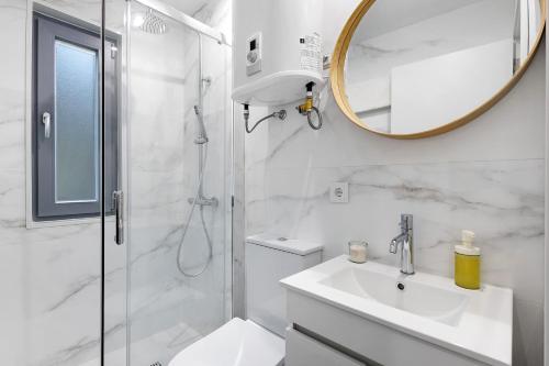 a bathroom with a shower and a sink and a mirror at Gerês Hideaway in Vilar da Veiga